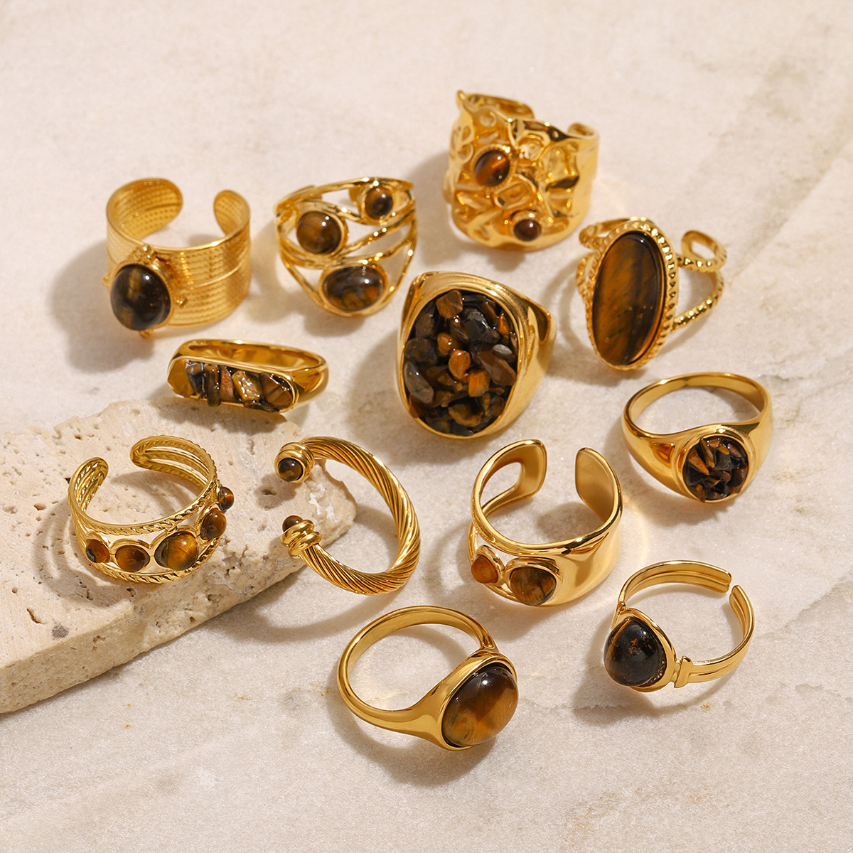 Collection of gold-plated rings with dark gemstone settings