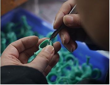 Close-up of jewelry wax carving process with green material