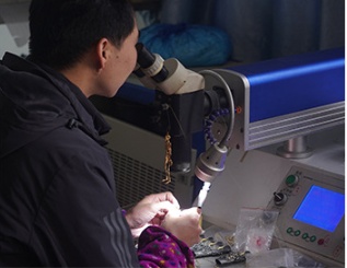 Jeweler examining piece under professional lighting equipment